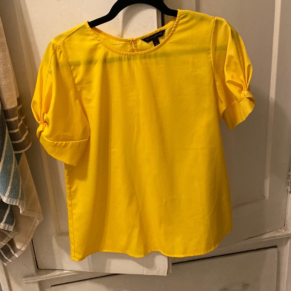 Yellow polka-dot work top with detailed puff sleeve.